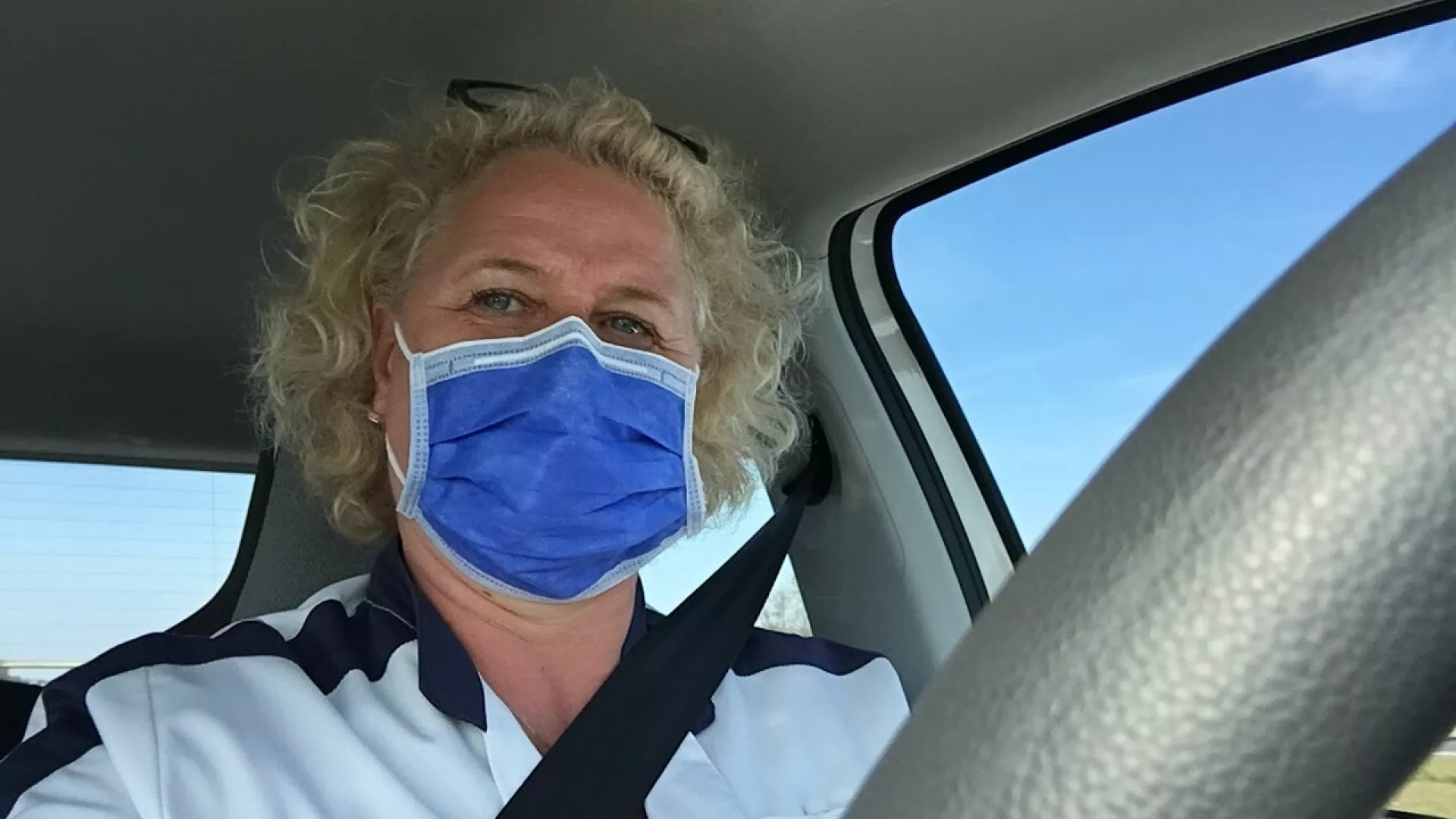 Functielaborant Hilde met mondkapje in auto