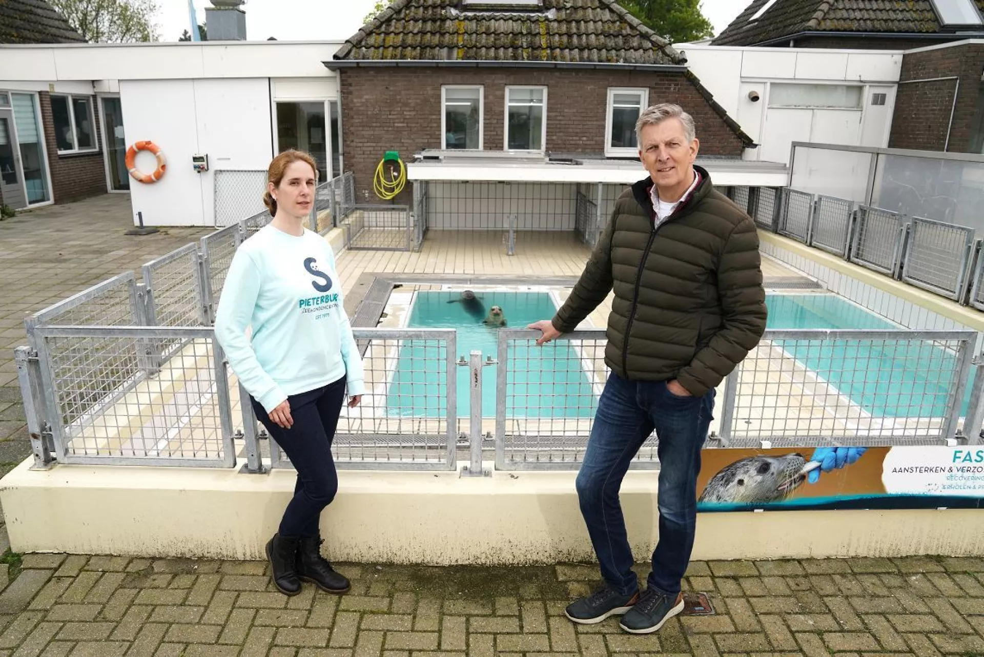 Ana Rubio Garcia en Jan van Zeijl voor zwembad met zeehond