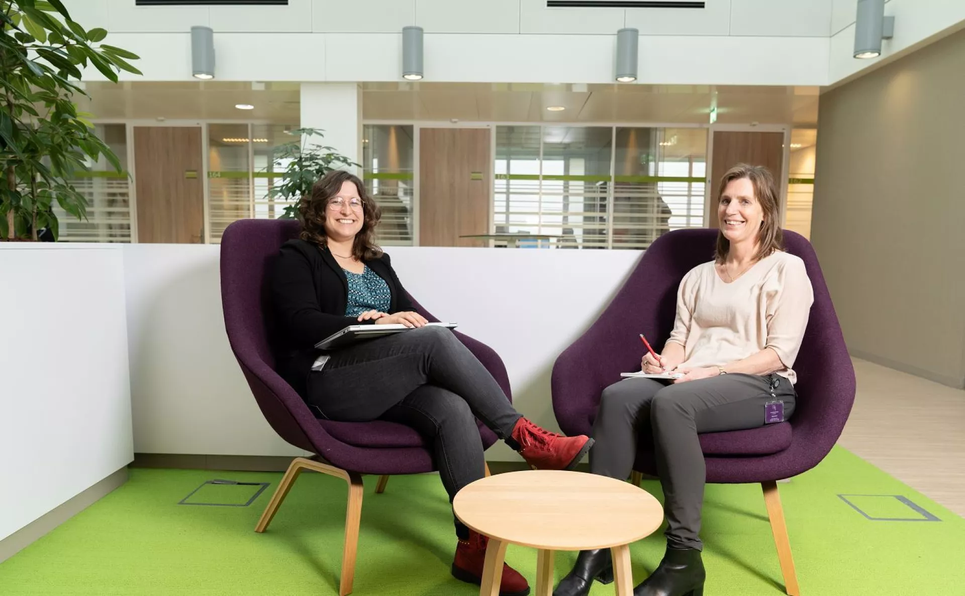 Sanne Huberts en Aleida Kuipers-Heijs zittend in paarse stoelen