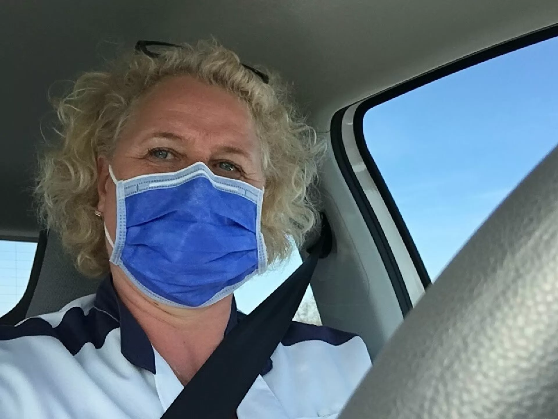 Functielaborant Hilde met mondkapje in auto
