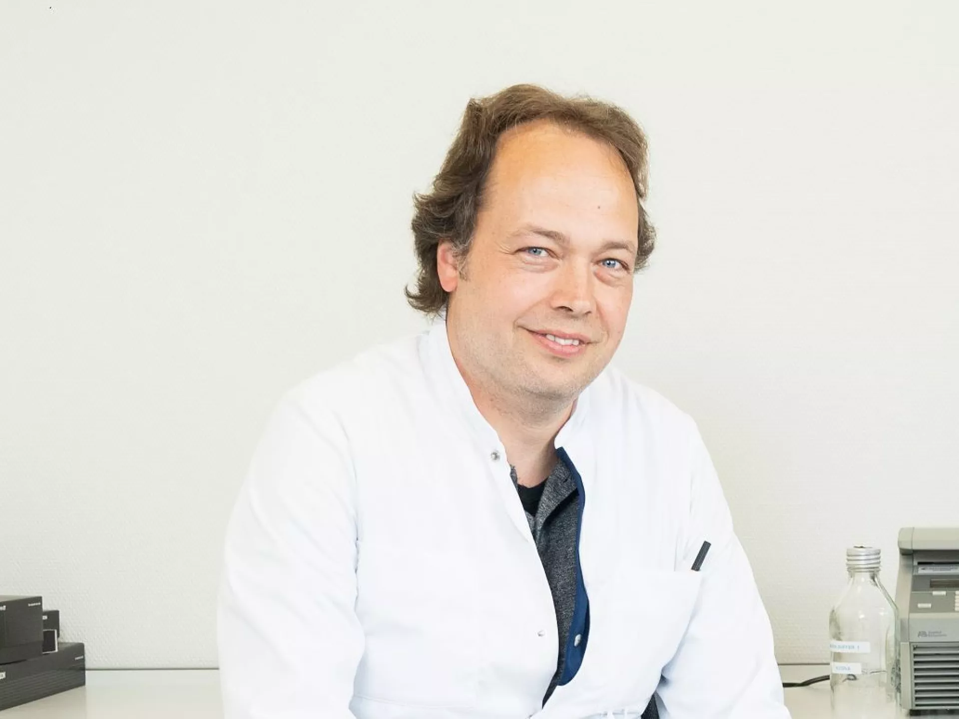 Robin Benus portret voor witte wand in labjas