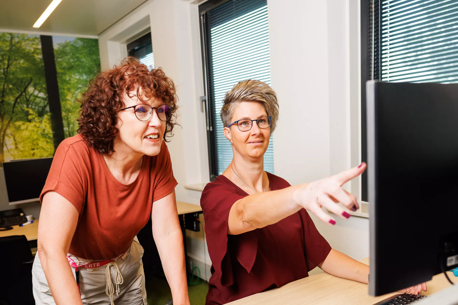 Twee dames wijzend naar computerscherm