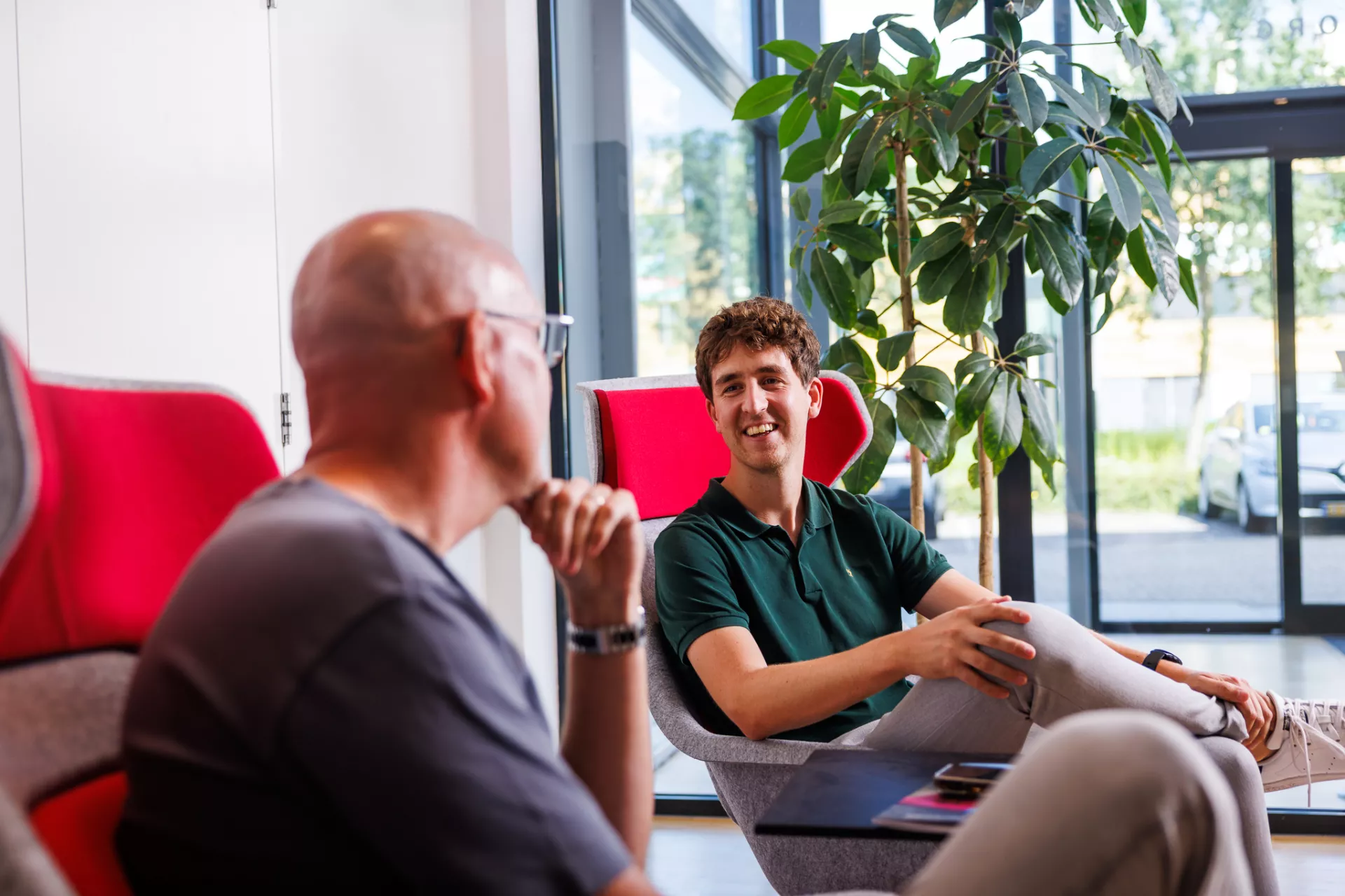 Twee heren zittend in rode stoelen 