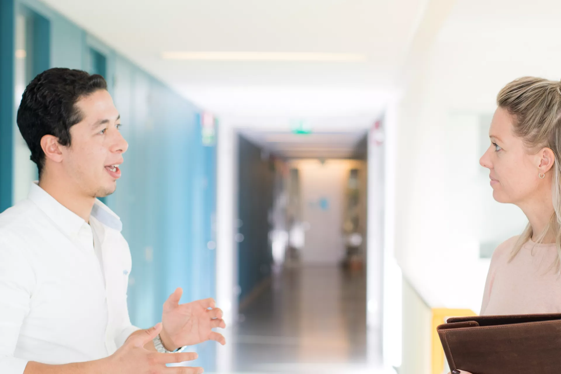 Man en vrouw in gang overleggend