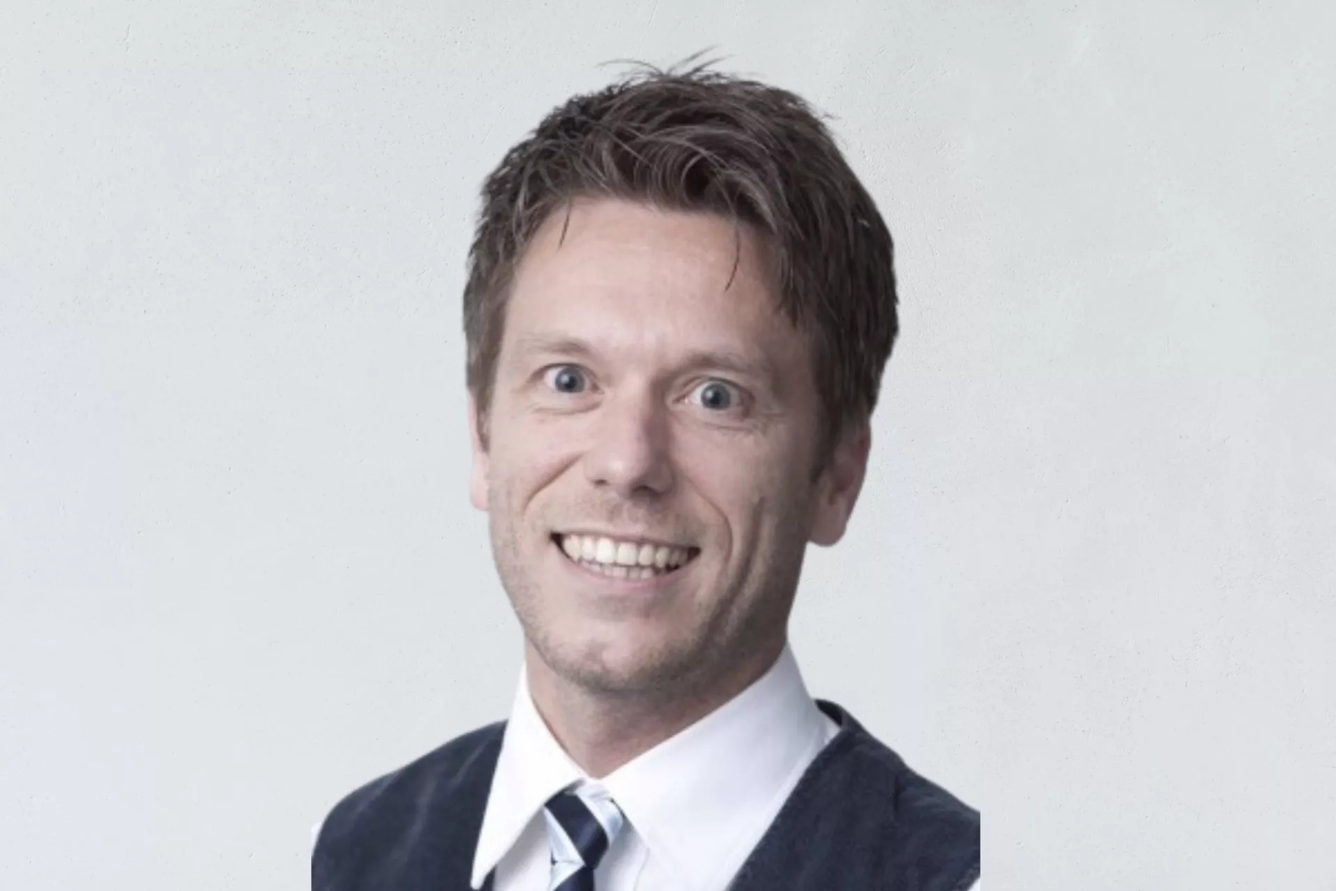 Portret Richard de Boer voor grijze wand