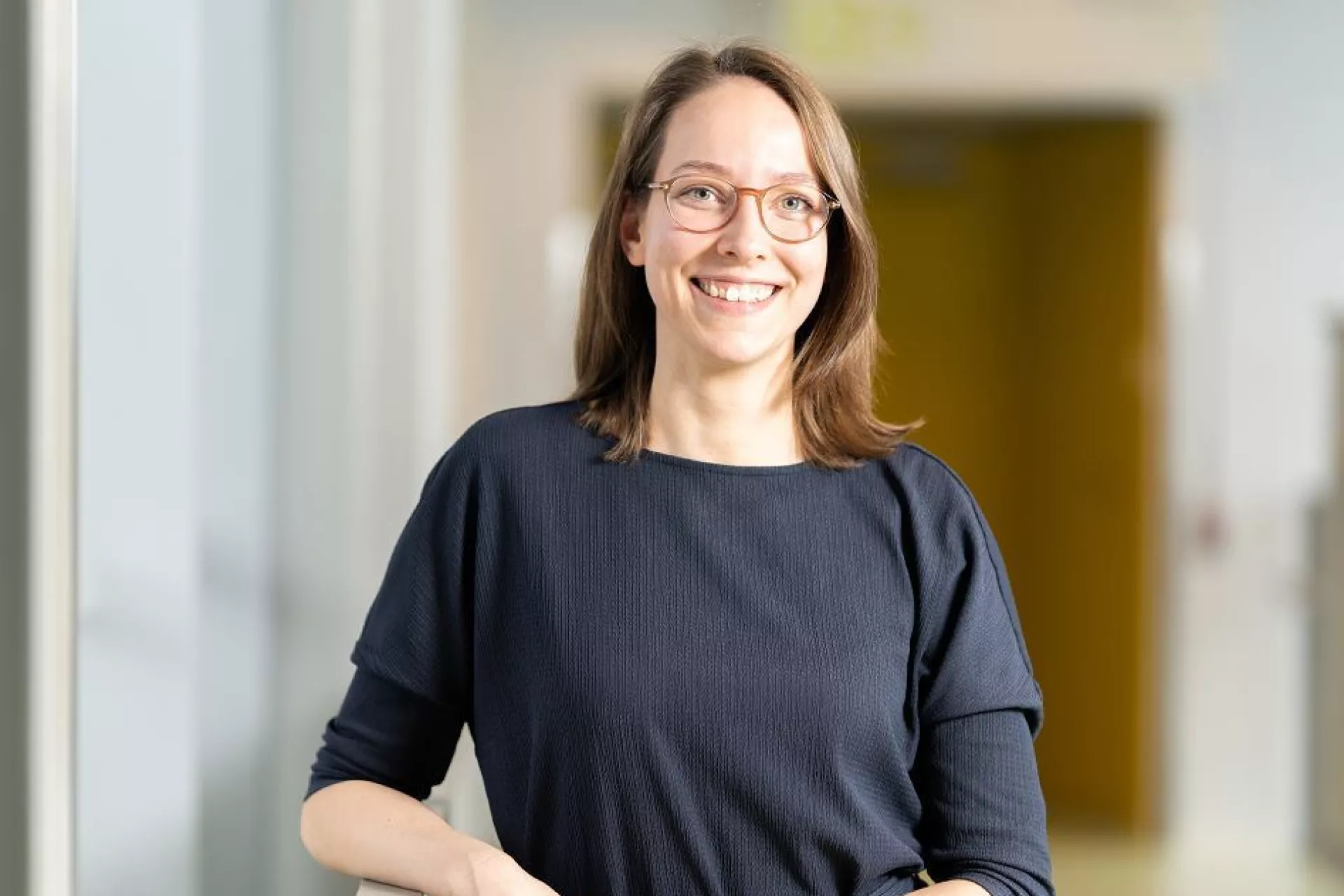 Portret Roos Houtsma in gang langs leuning