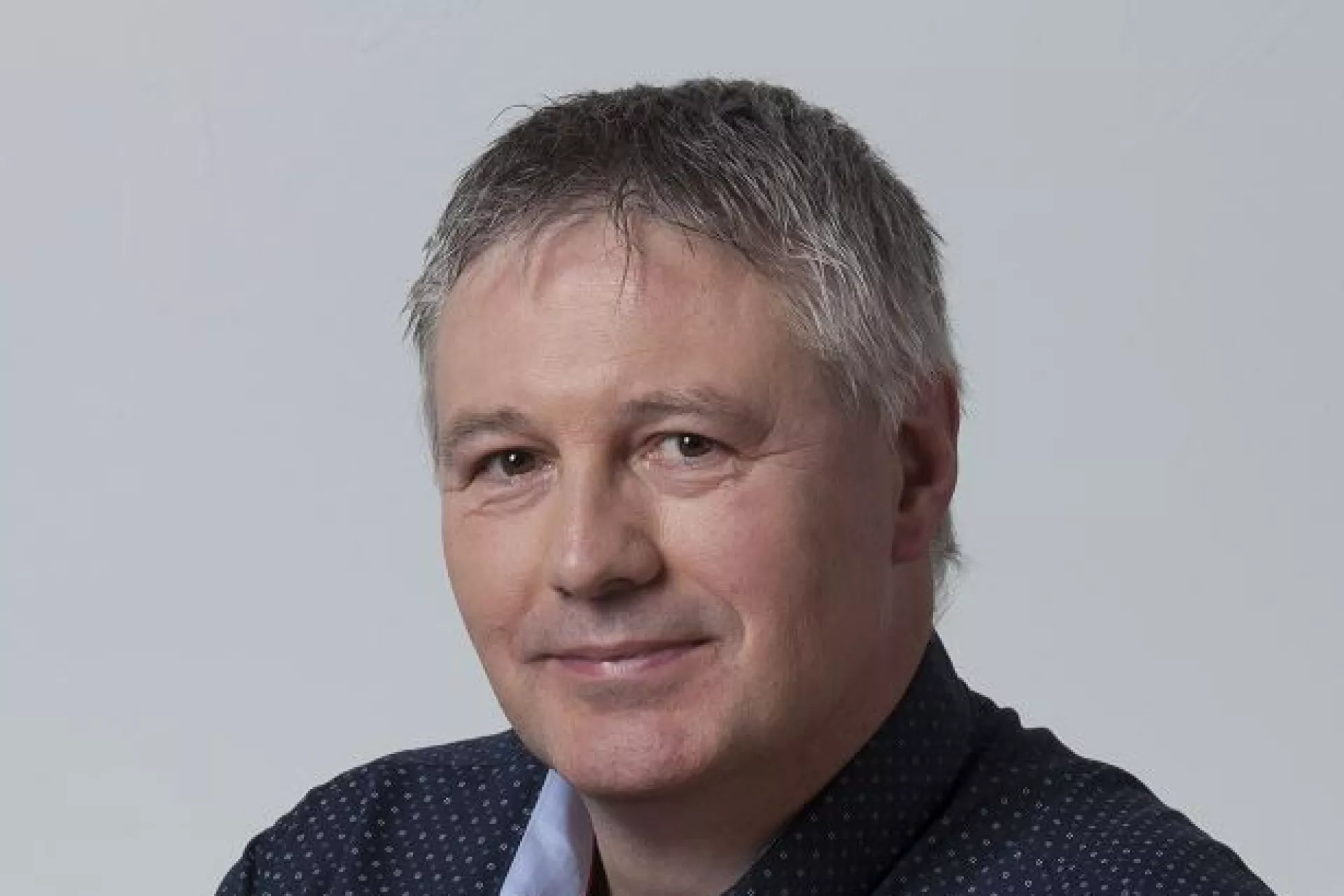 Portret Albert Wolthuis voor grijze wand