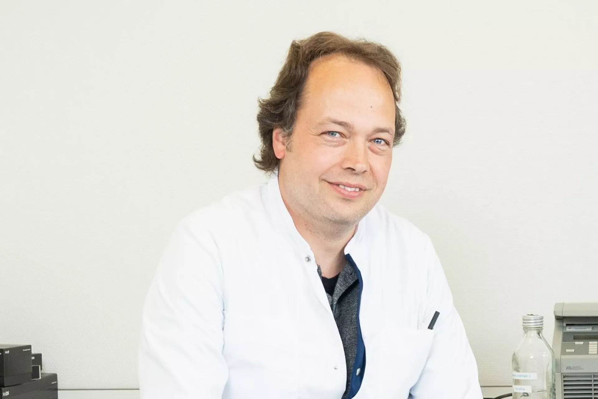 Robin Benus portret voor witte wand in labjas