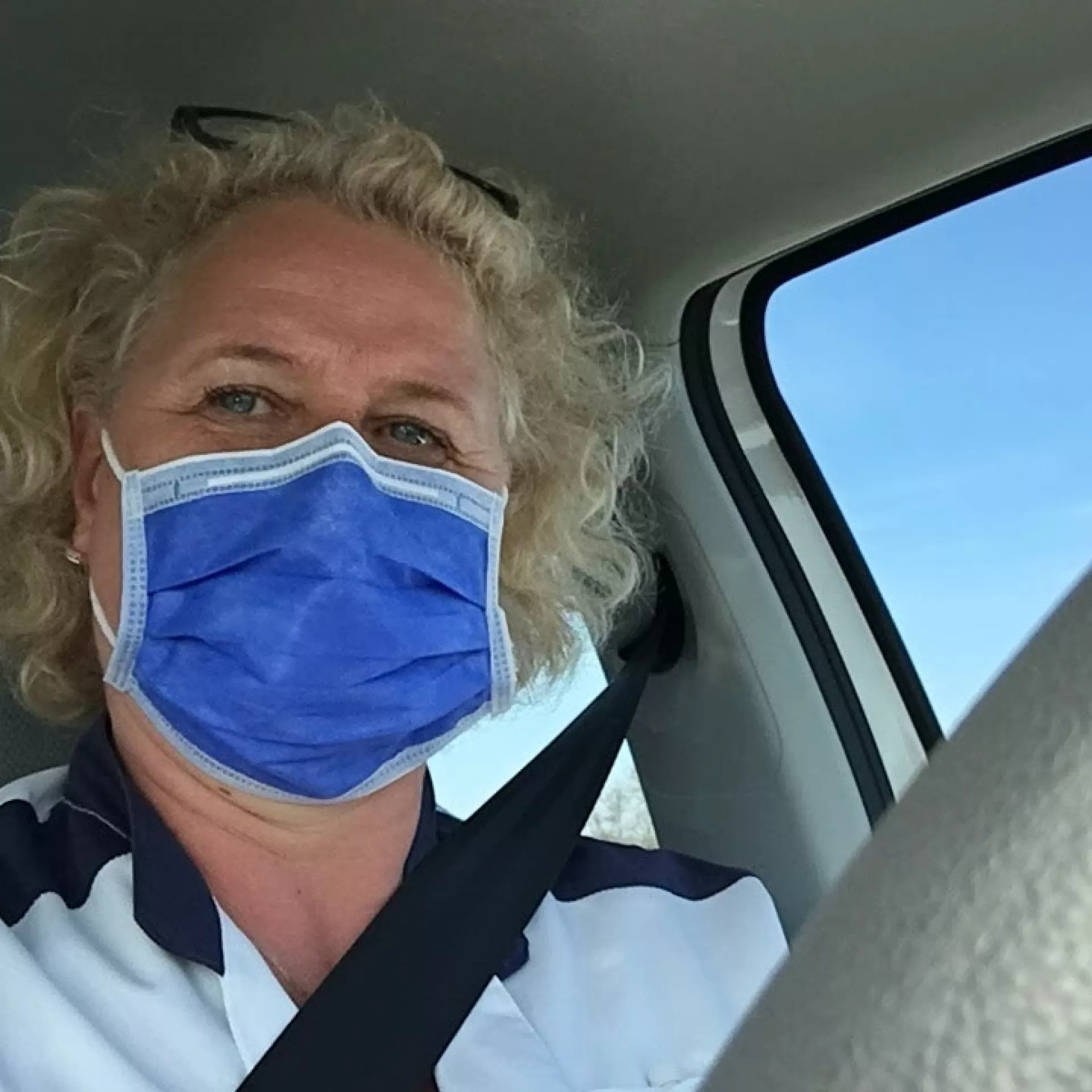 Functielaborant Hilde met mondkapje in auto