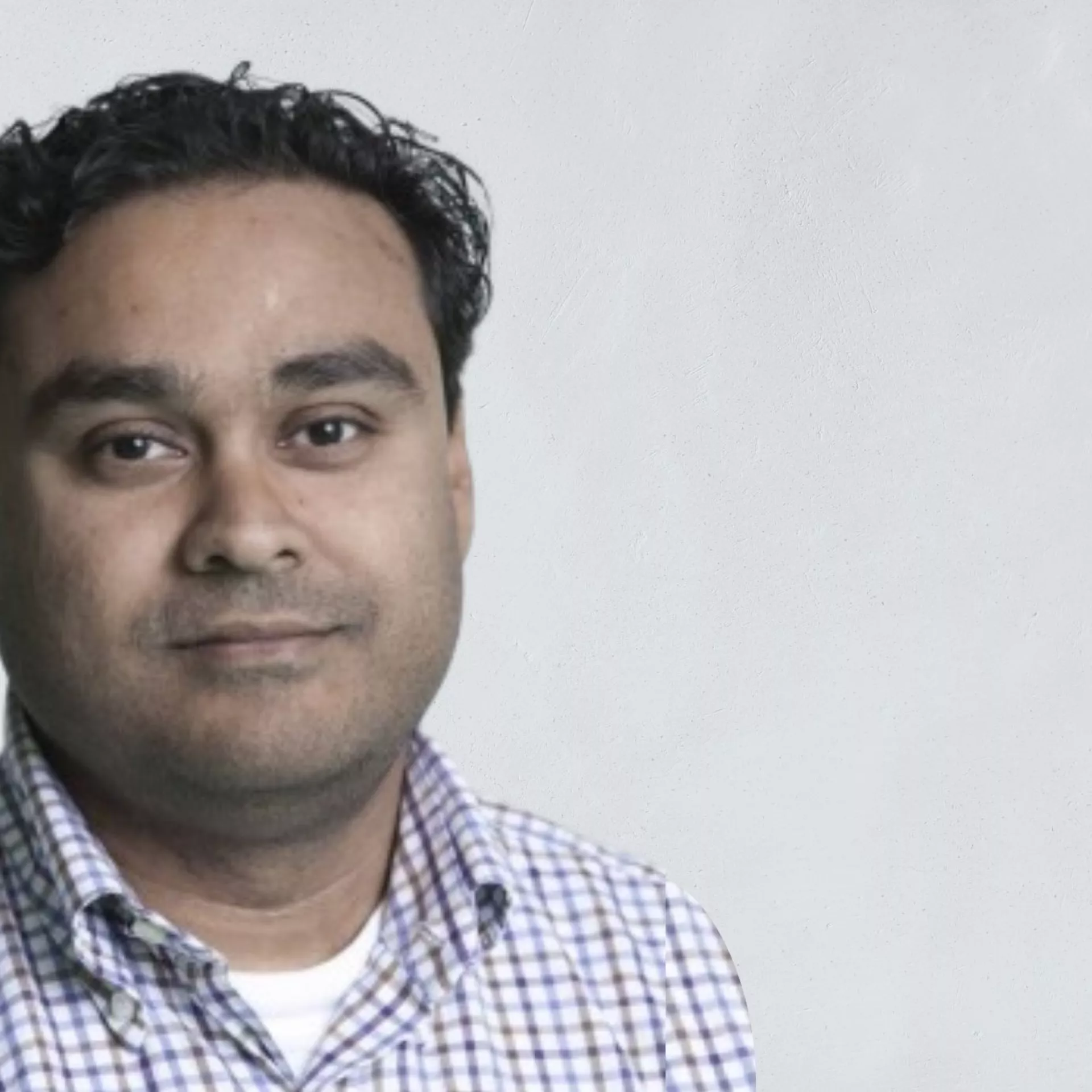 Portret Glen Mithoe voor grijze wand