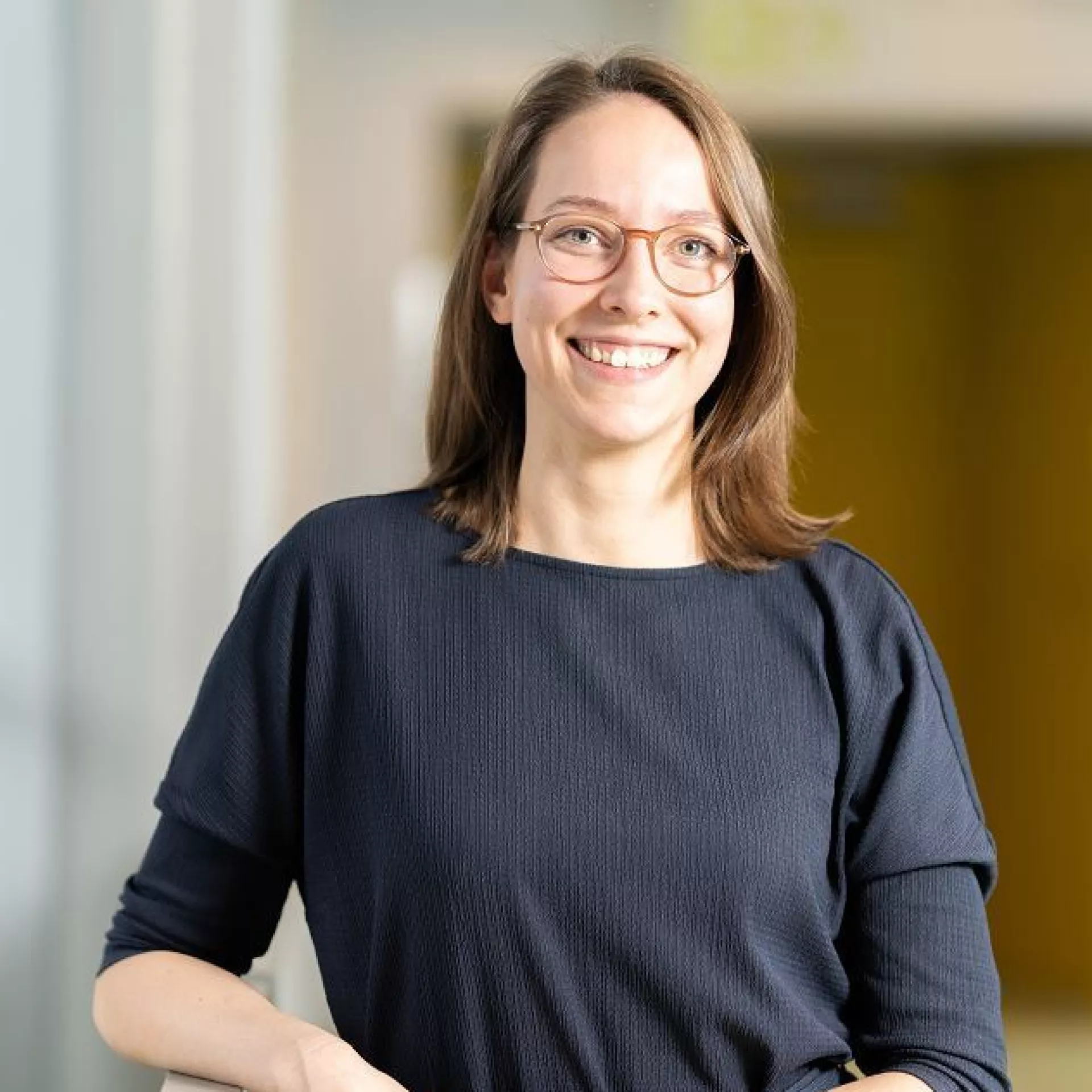 Portret Roos Houtsma in gang langs leuning