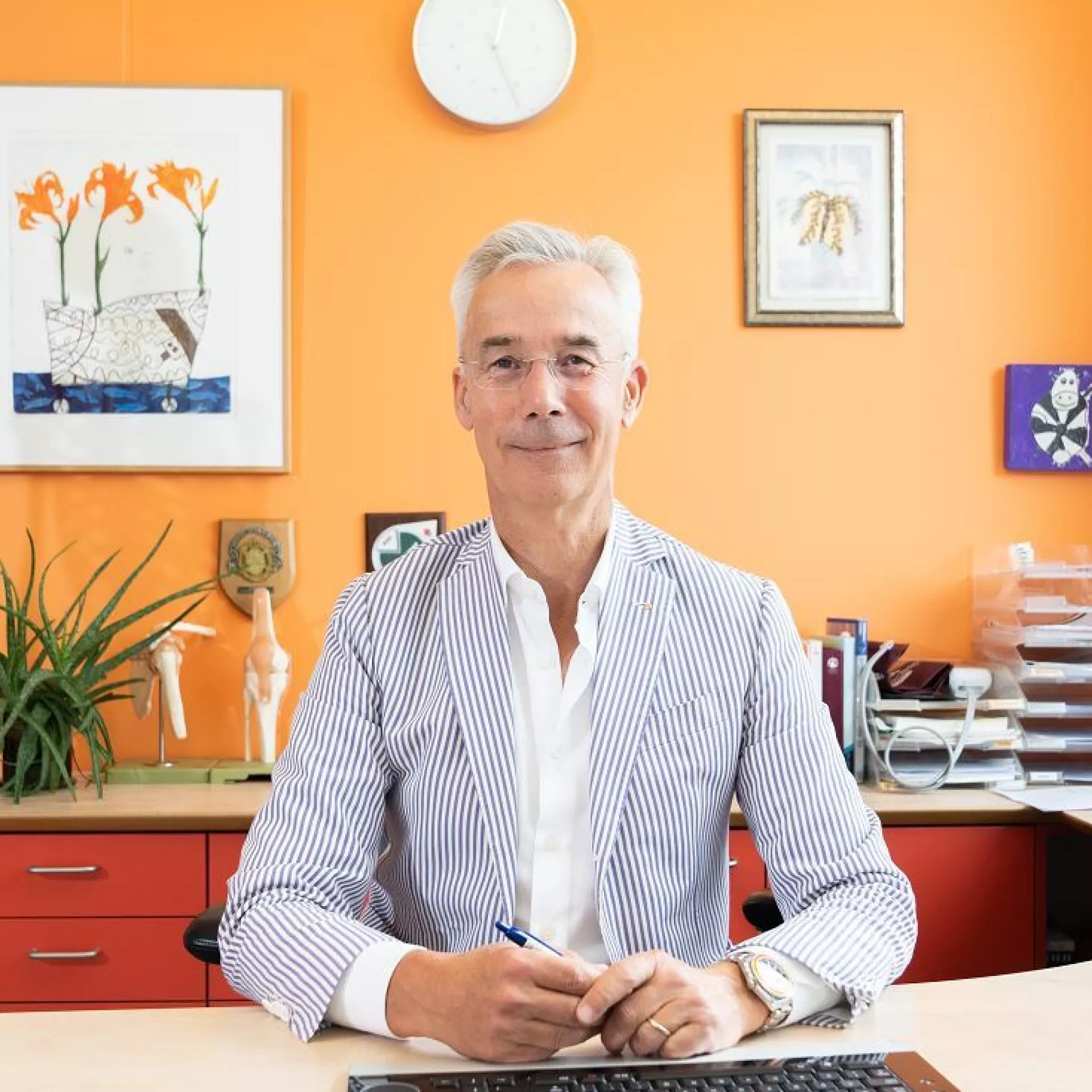 Sander Jonges huisarts aan bureau voor oranje wand
