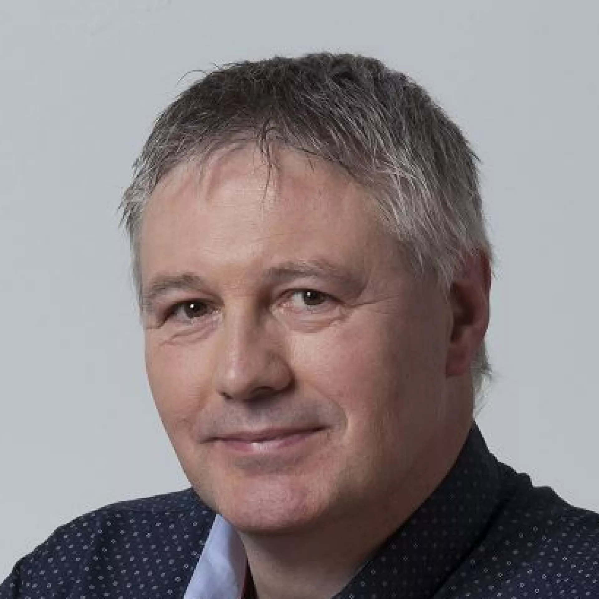 Portret Albert Wolthuis voor grijze wand