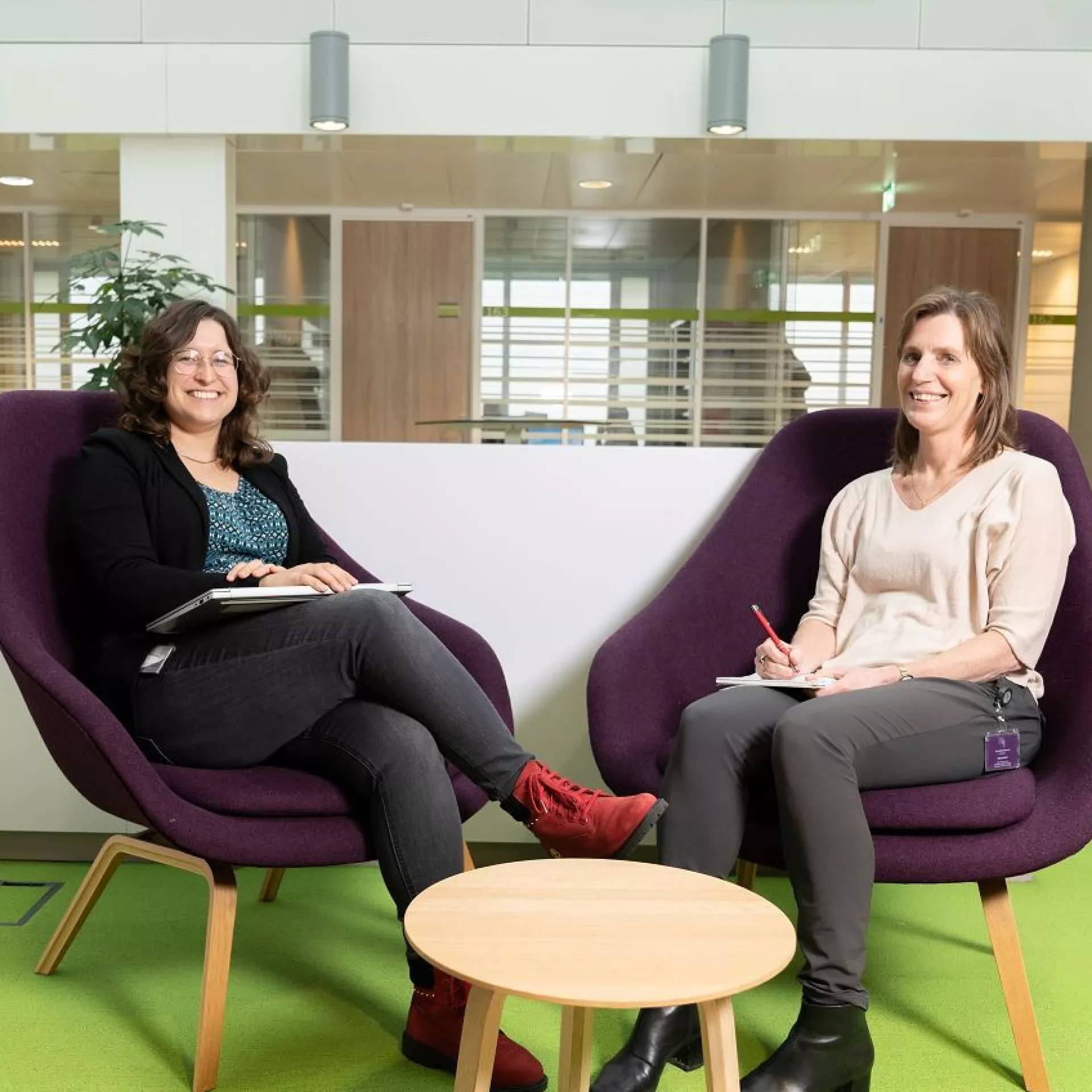 Sanne Huberts en Aleida Kuipers-Heijs zittend in paarse stoelen