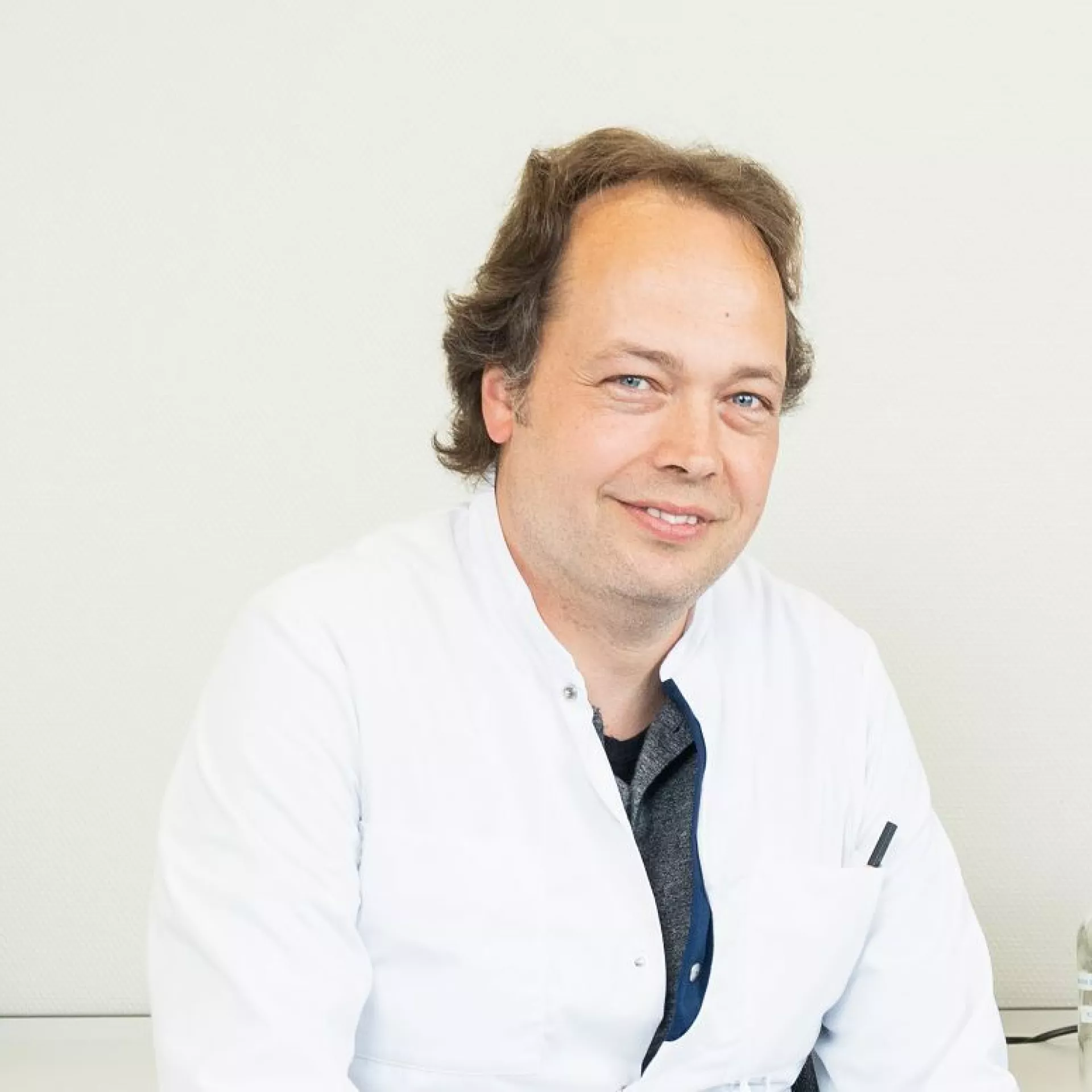 Robin Benus portret voor witte wand in labjas